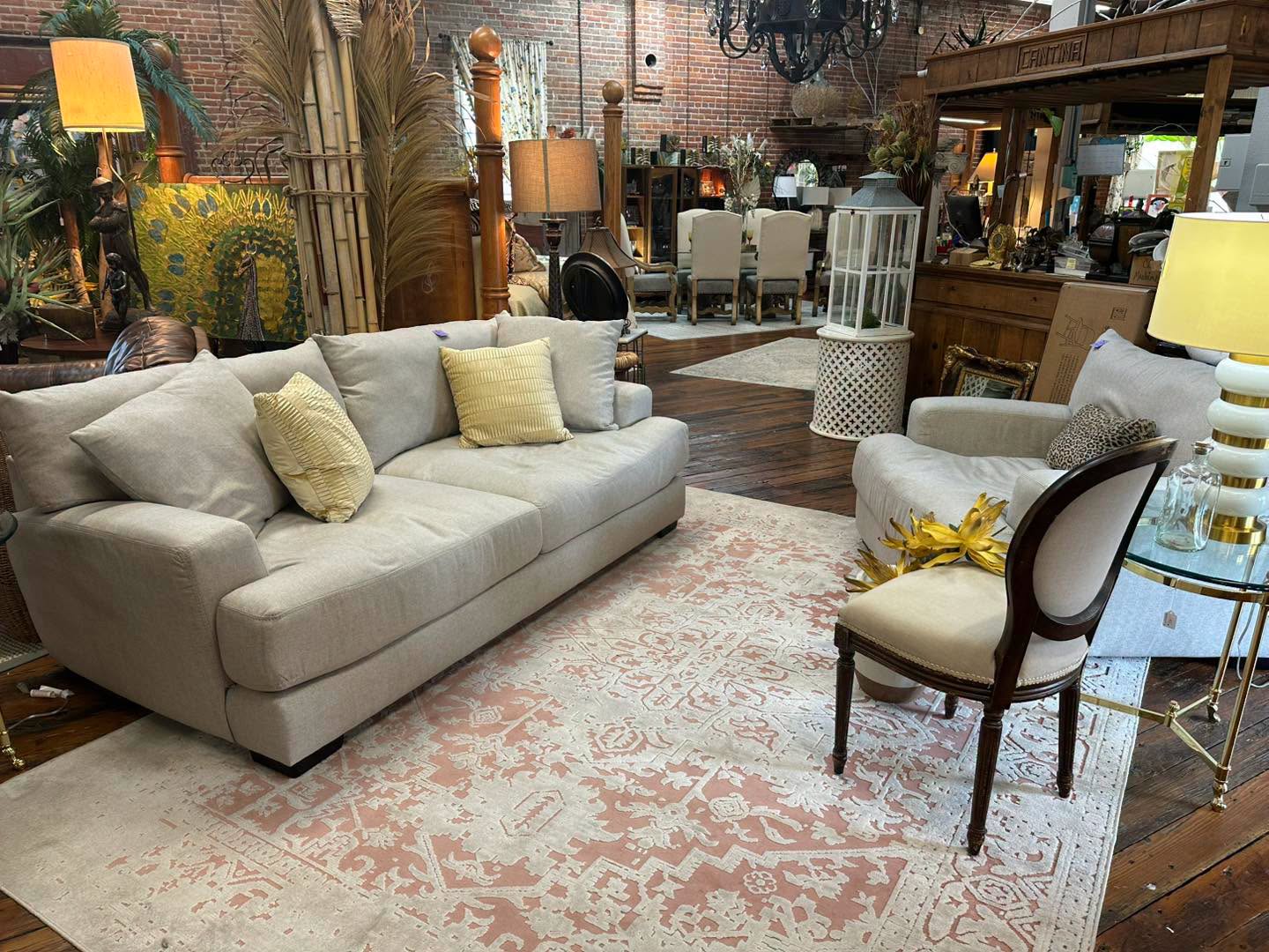 Cream sofa styled with blush rug, brass lamp, and fresh flowers